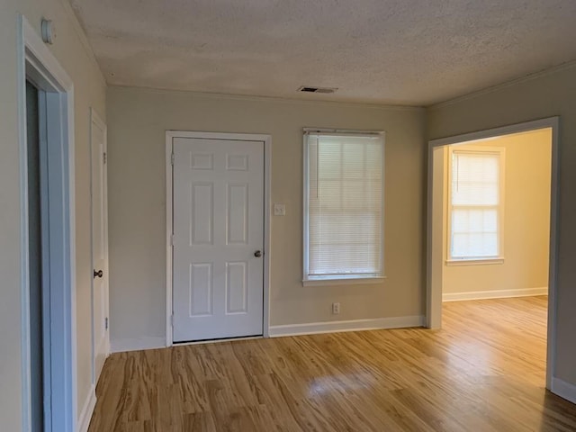 foyer featuring light hardwood / wood-style flooring and a textured ceiling