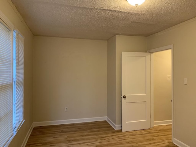 unfurnished room featuring wood-type flooring and a textured ceiling