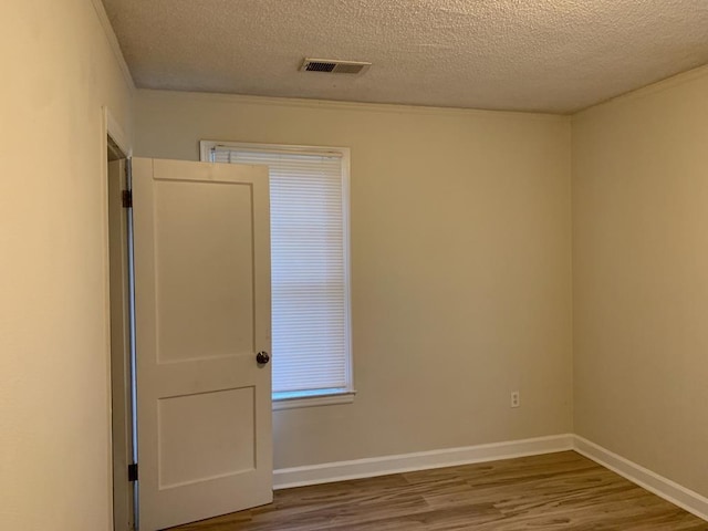 spare room with wood-type flooring and a textured ceiling