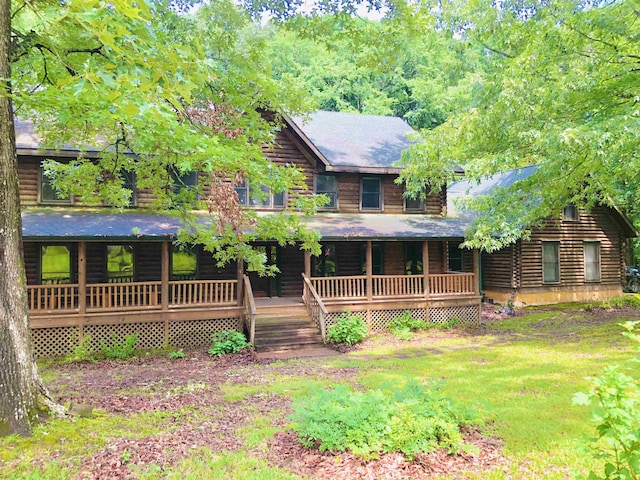 view of front of home featuring covered porch and a yard