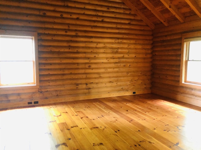 spare room featuring lofted ceiling with beams, log walls, wood ceiling, and light hardwood / wood-style flooring