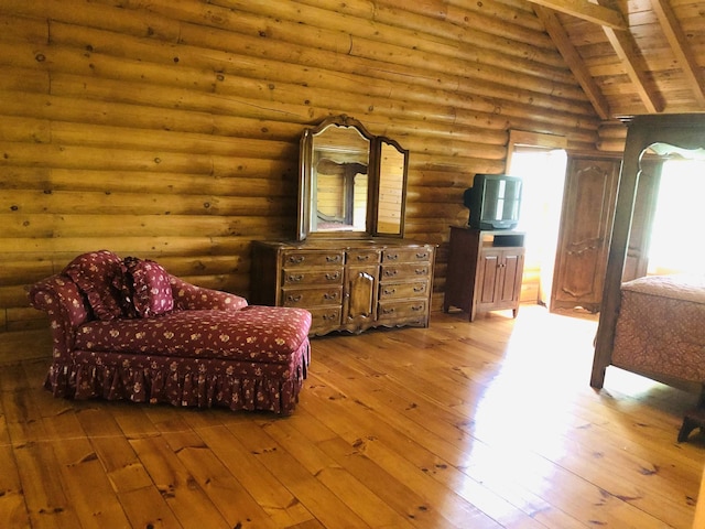 living area featuring wooden ceiling, rustic walls, vaulted ceiling with beams, and wood finished floors