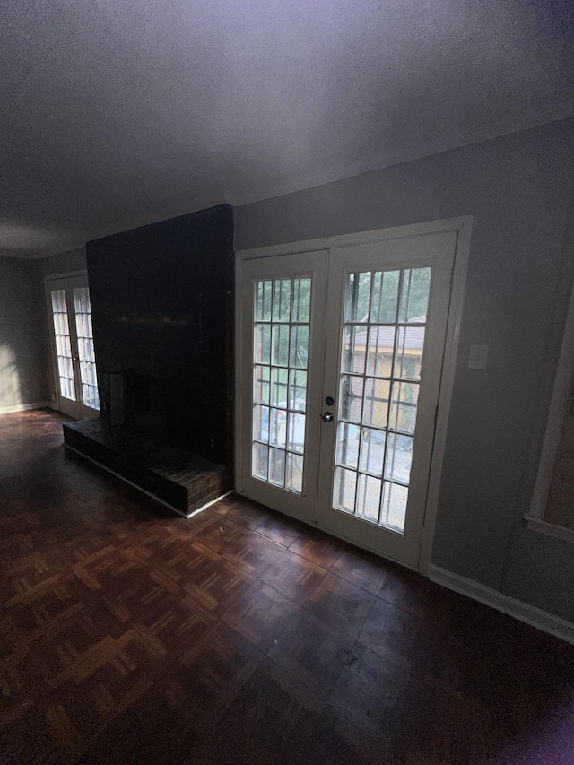 doorway featuring dark parquet floors, french doors, and a textured ceiling