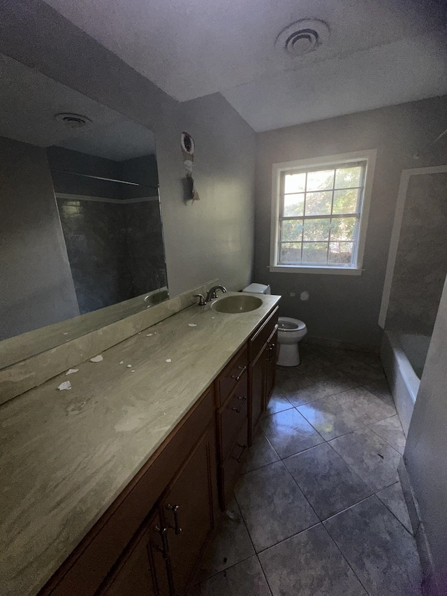 bathroom with vanity, toilet, tile patterned flooring, and a textured ceiling