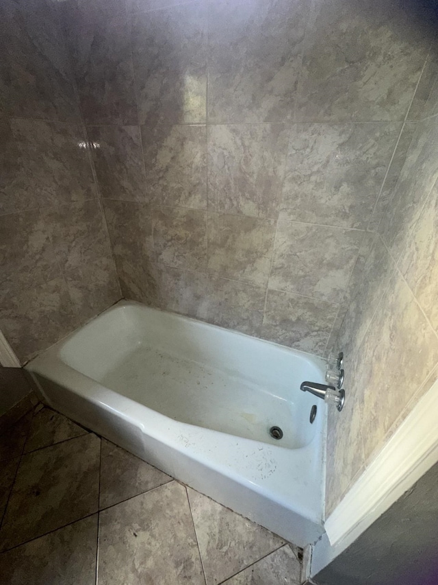 bathroom with a bath and tile patterned floors