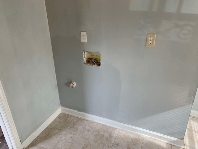 clothes washing area featuring light tile patterned flooring and washer hookup