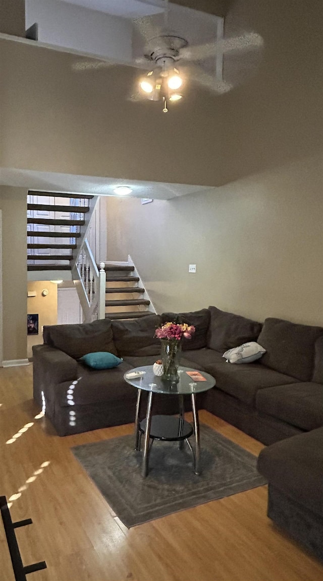 living room featuring wood-type flooring and ceiling fan