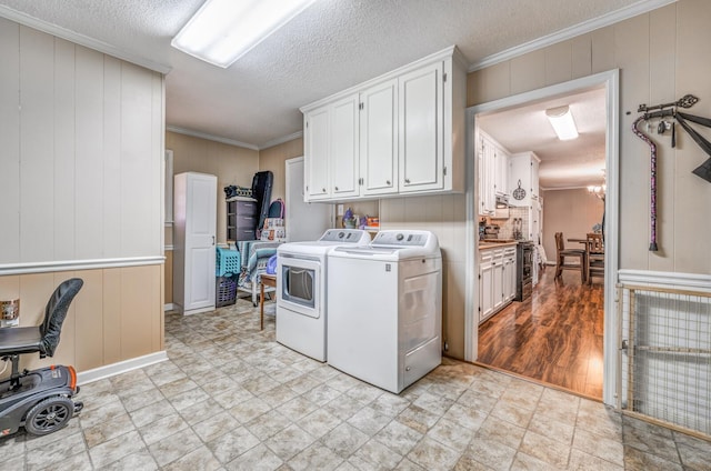 washroom featuring cabinets, ornamental molding, independent washer and dryer, a textured ceiling, and an inviting chandelier