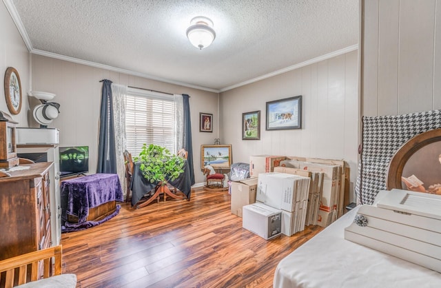 bedroom with hardwood / wood-style floors, crown molding, and a textured ceiling