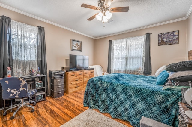 bedroom with ceiling fan, ornamental molding, hardwood / wood-style floors, and a textured ceiling