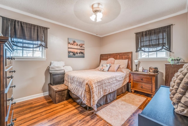 bedroom with ornamental molding, hardwood / wood-style floors, and a textured ceiling