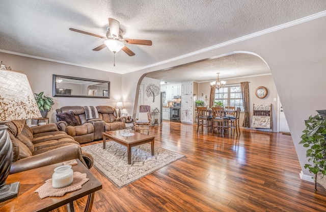 living room featuring ornamental molding, dark hardwood / wood-style floors, ceiling fan with notable chandelier, and a textured ceiling