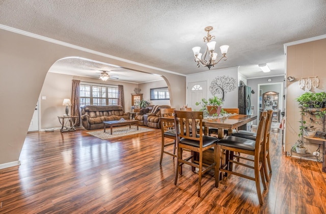 dining area featuring ornamental molding, dark wood-type flooring, and a textured ceiling