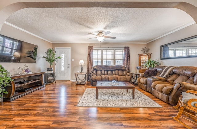 living room with wood-type flooring, ornamental molding, and a wealth of natural light