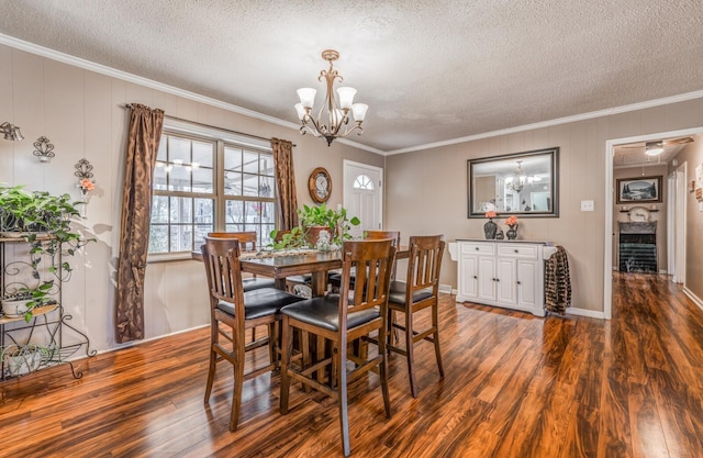 dining room with crown molding, dark wood-type flooring, a notable chandelier, and a textured ceiling