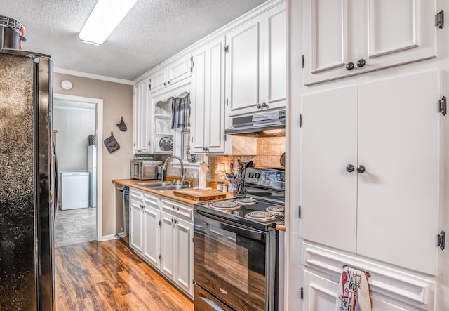 kitchen with sink, white cabinetry, tasteful backsplash, wood-type flooring, and black appliances