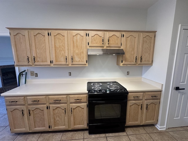 kitchen with light brown cabinetry, light tile patterned floors, and electric range