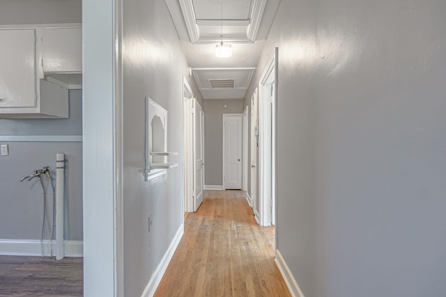 hall with light wood-type flooring and a tray ceiling