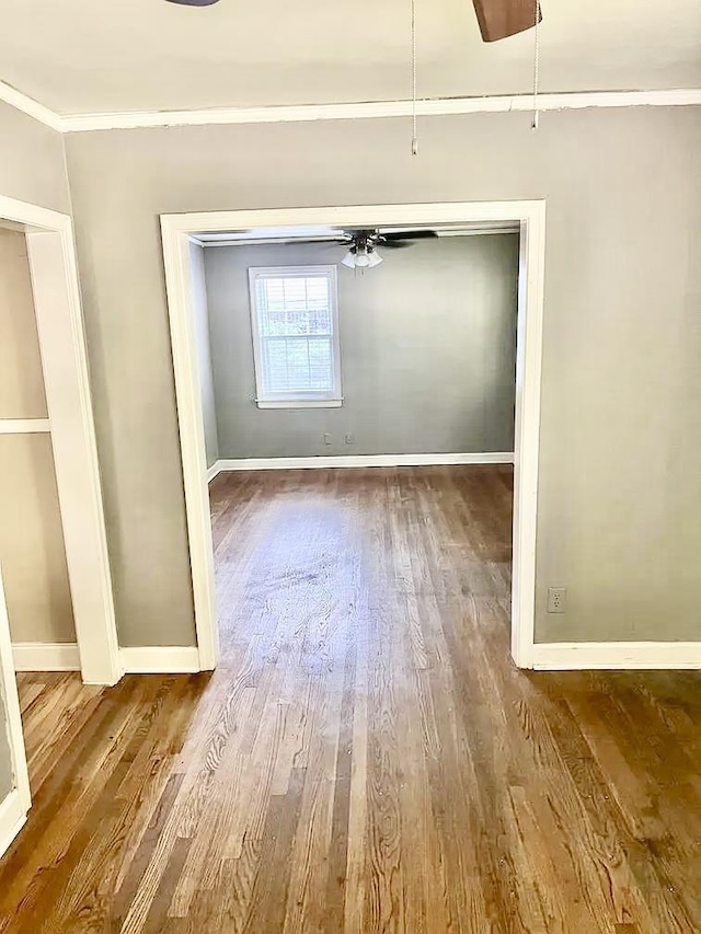 empty room featuring hardwood / wood-style flooring, ceiling fan, and crown molding