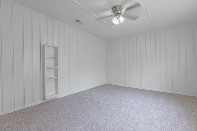 spare room featuring ceiling fan, carpet flooring, and built in features