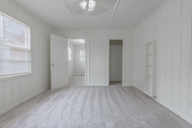 unfurnished bedroom with light carpet, ceiling fan, and a closet