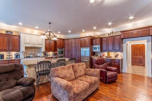 living room featuring hardwood / wood-style flooring, ornamental molding, and sink