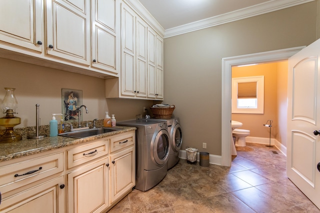 laundry room with cabinets, ornamental molding, sink, and washer and clothes dryer