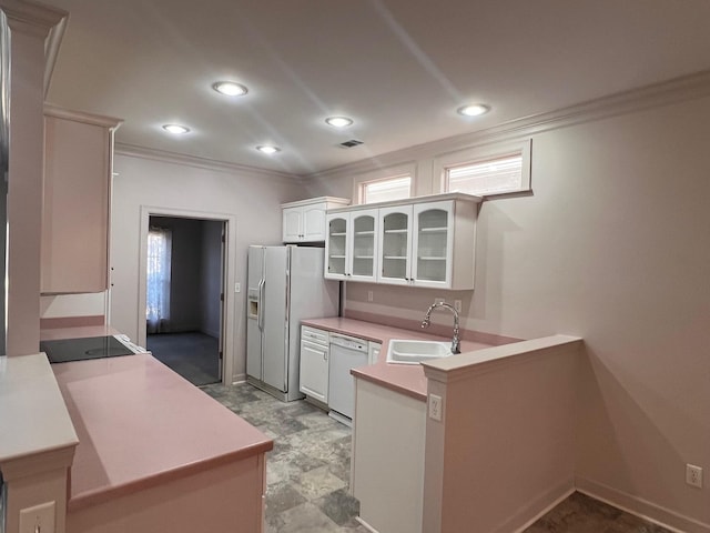 kitchen with white cabinetry, sink, ornamental molding, kitchen peninsula, and white appliances