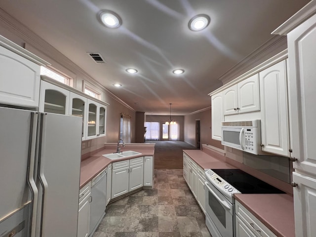 kitchen with hanging light fixtures, white cabinets, white appliances, and kitchen peninsula