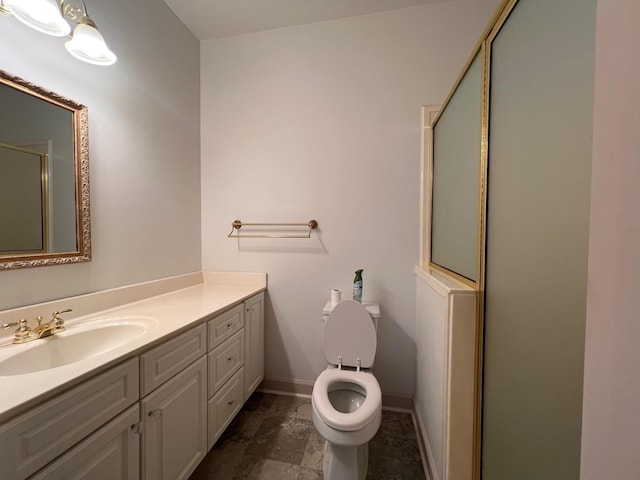 bathroom featuring walk in shower, vanity, and toilet