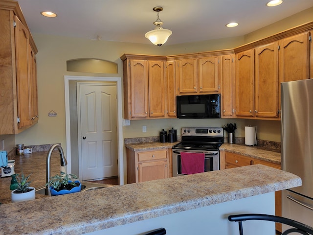 kitchen featuring appliances with stainless steel finishes, decorative light fixtures, kitchen peninsula, and sink