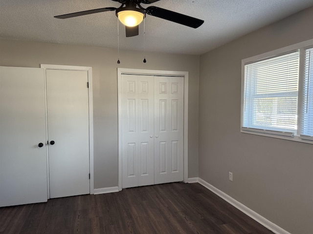 unfurnished bedroom with ceiling fan, dark hardwood / wood-style flooring, and a textured ceiling