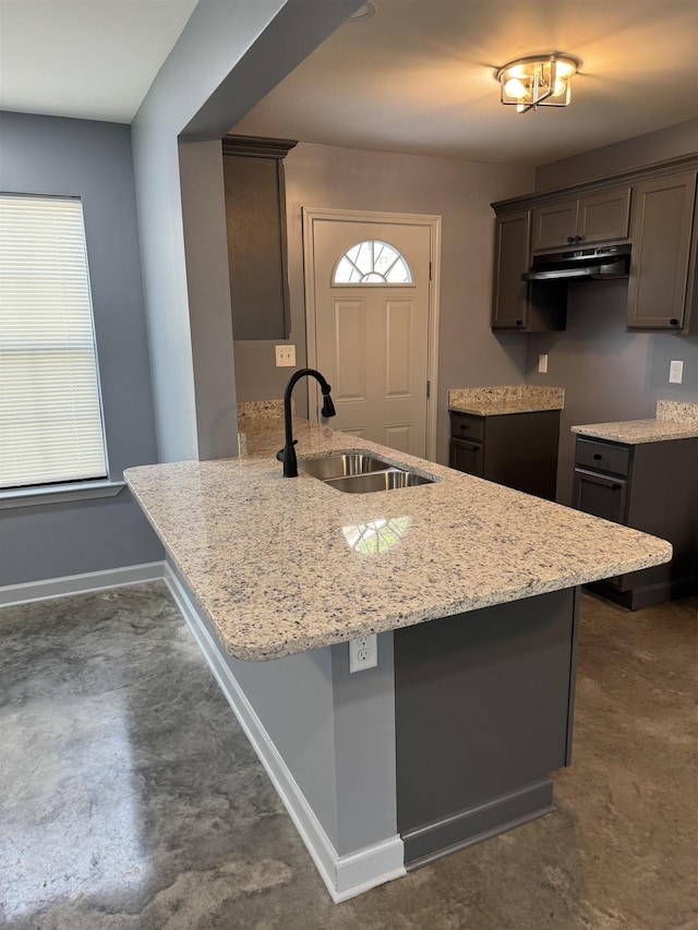 153 Caldwell Ave, Memphis, TN 38107 - kitchen with a sink, under cabinet range hood, a peninsula, light stone countertops, and baseboards