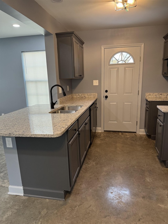 153 Caldwell Ave, Memphis, TN 38107 - kitchen with a sink, unfinished concrete floors, a peninsula, light stone counters, and dishwasher