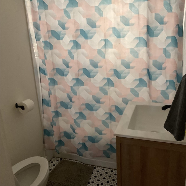 bathroom featuring tile patterned floors, toilet, curtained shower, and vanity