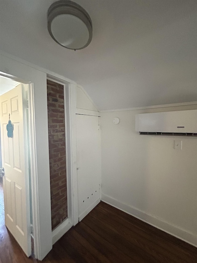 bonus room with dark hardwood / wood-style flooring, vaulted ceiling, and a wall unit AC