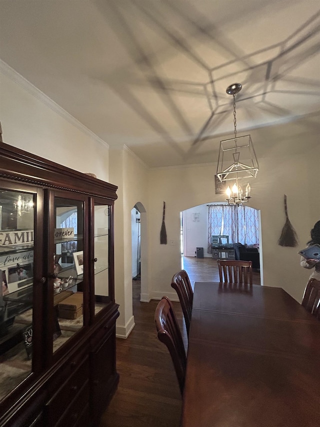 dining room with an inviting chandelier, dark wood-type flooring, and ornamental molding