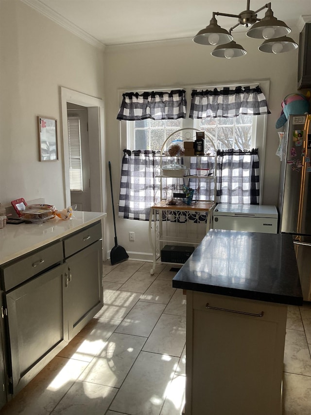 kitchen featuring ornamental molding, a kitchen island, and gray cabinetry