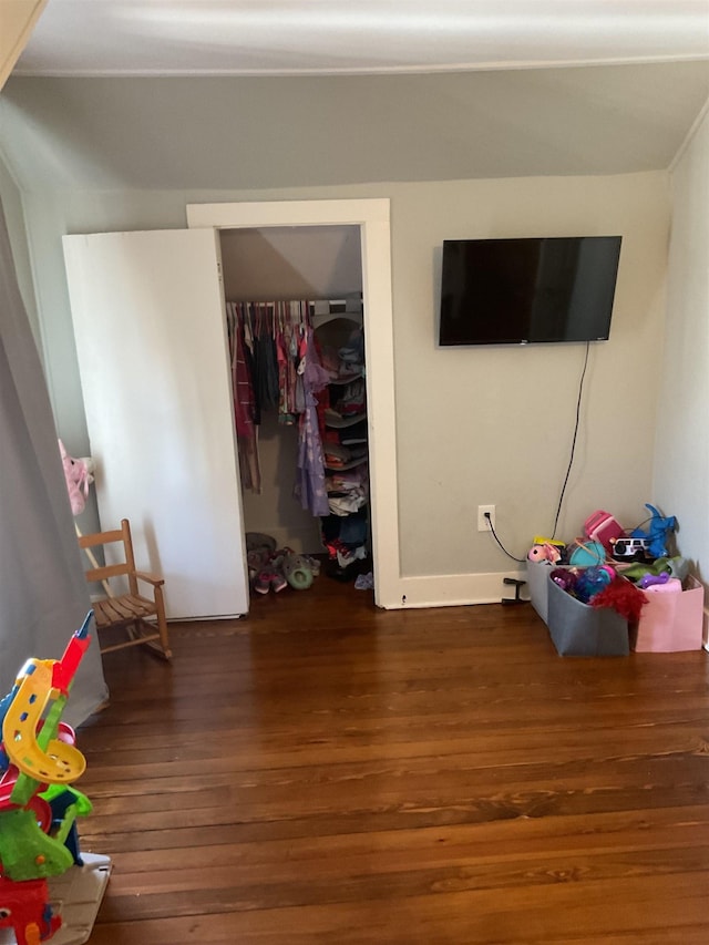 bedroom with dark hardwood / wood-style flooring and a closet