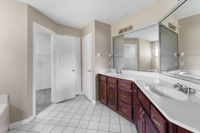 bathroom featuring tile patterned floors, vanity, and a textured ceiling