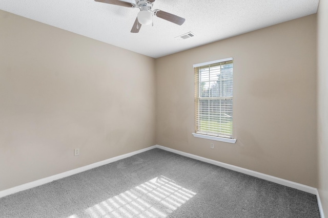 carpeted empty room featuring ceiling fan and a textured ceiling