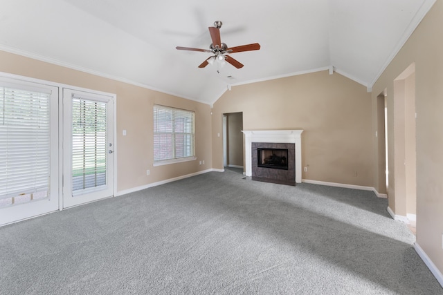 unfurnished living room with a tiled fireplace, crown molding, lofted ceiling, and carpet