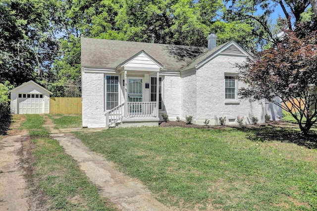 view of front of property featuring a garage, an outdoor structure, and a front yard