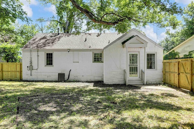 back of property featuring central AC unit and a lawn