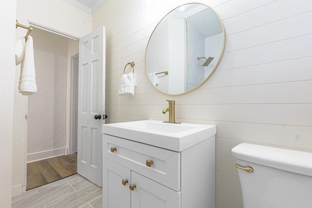 bathroom featuring vanity, ornamental molding, and toilet