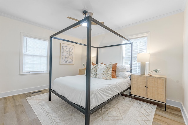 bedroom featuring crown molding, wood-type flooring, and ceiling fan