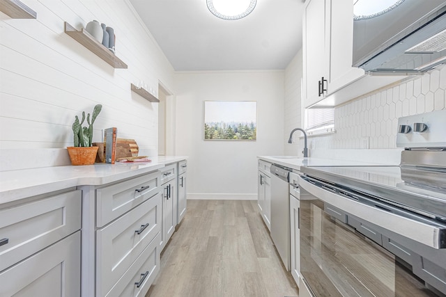 kitchen featuring sink, appliances with stainless steel finishes, tasteful backsplash, white cabinets, and light wood-type flooring