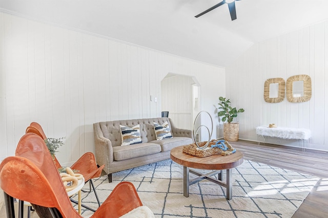 living room with light hardwood / wood-style flooring, vaulted ceiling, and ceiling fan