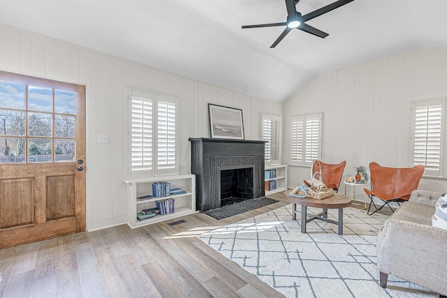 living room featuring vaulted ceiling, ceiling fan, and light hardwood / wood-style flooring