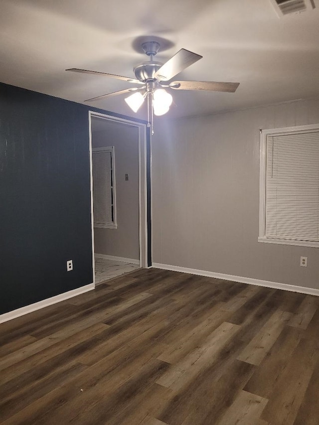 empty room with ceiling fan and dark hardwood / wood-style flooring